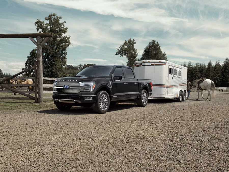 Ford F-150 towing a horse trailer in a rural lifestyle setting