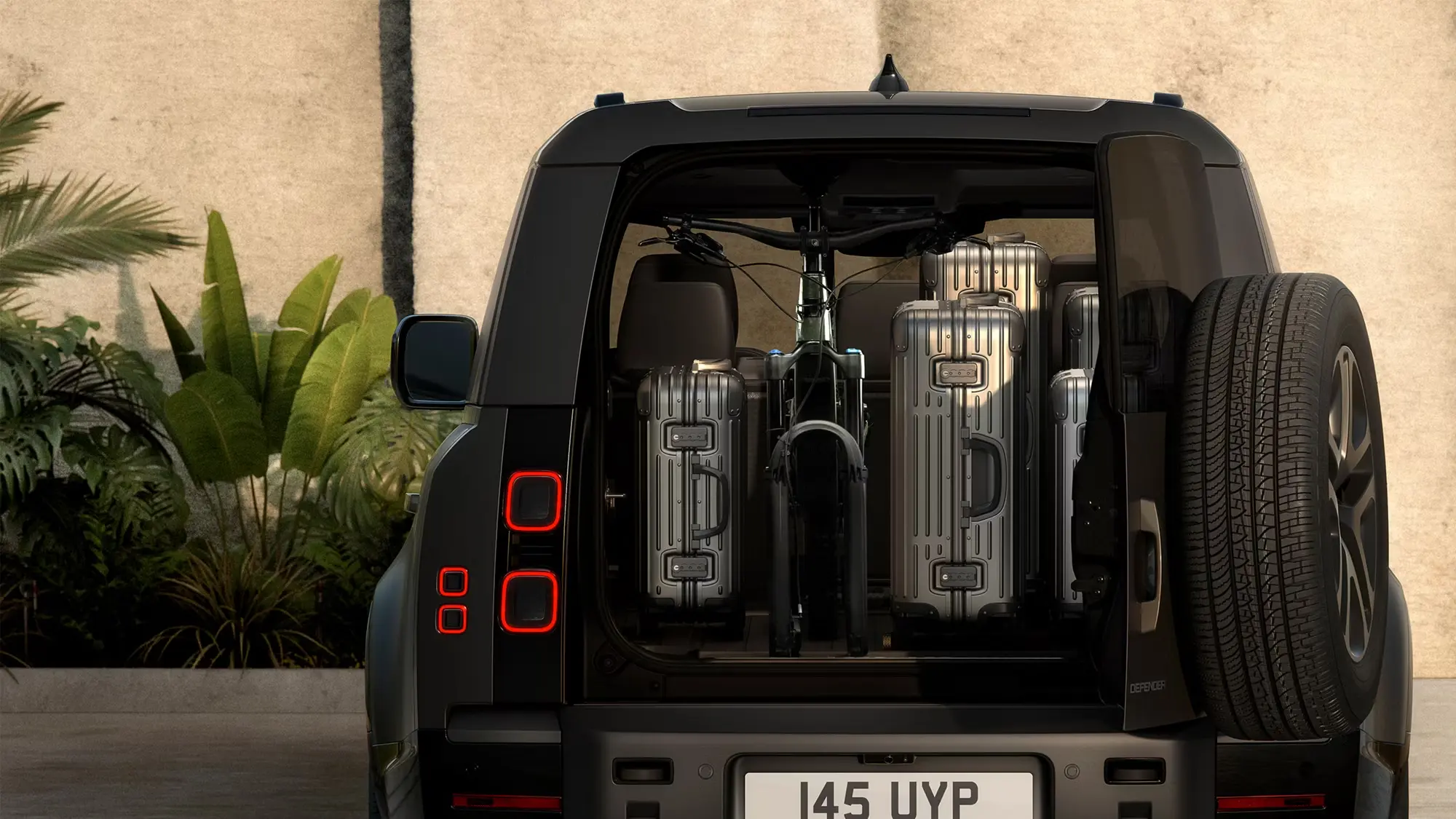 Defender 130 cargo area carrying luggage and a bicycle