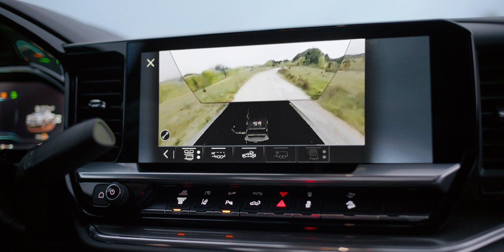 Silverado HD center touchscreen showing a rear trailer camera view of a gravel road